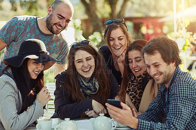 Buy stock photo Cropped shot of a group of friends looking at something funny on a cellphone
