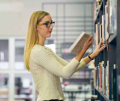 Buy stock photo Cropped shot of an attractive young university student browsing the campus library for a book