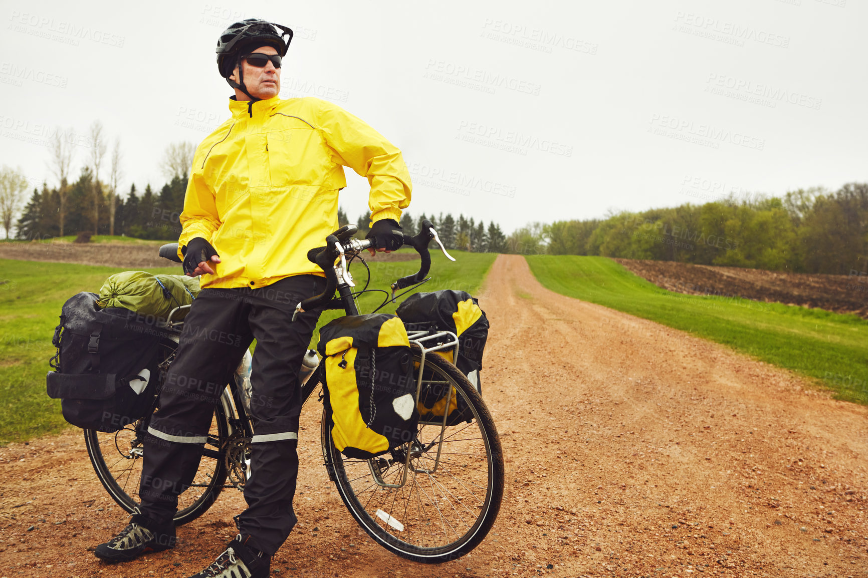 Buy stock photo Cropped shot of a male cyclist enjoying a bike ride on a wet winter's morning