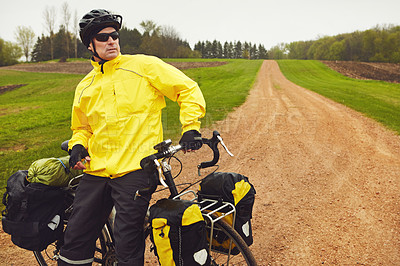 Buy stock photo Cropped shot of a male cyclist enjoying a bike ride on a wet winter's morning