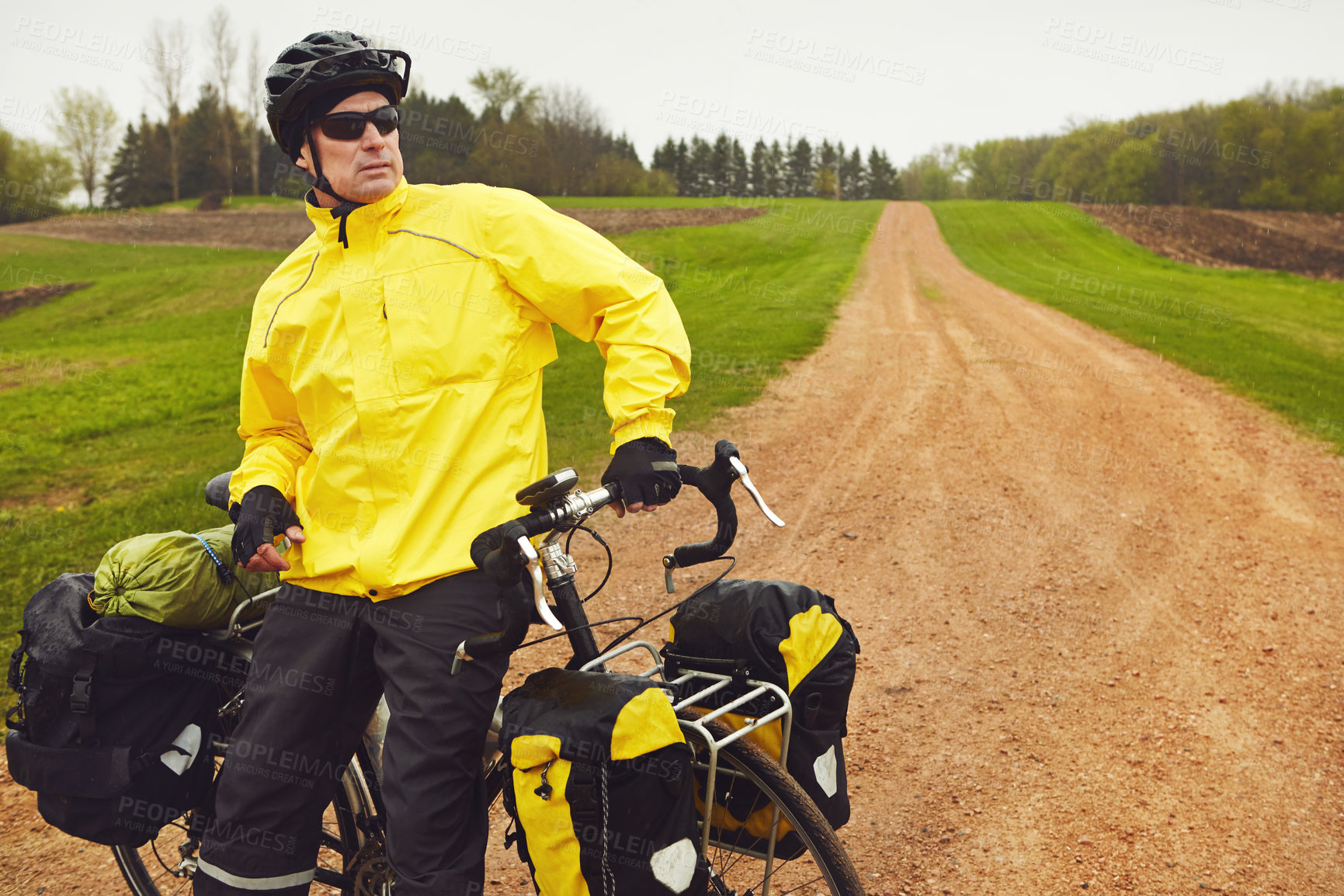 Buy stock photo Cropped shot of a male cyclist enjoying a bike ride on a wet winter's morning