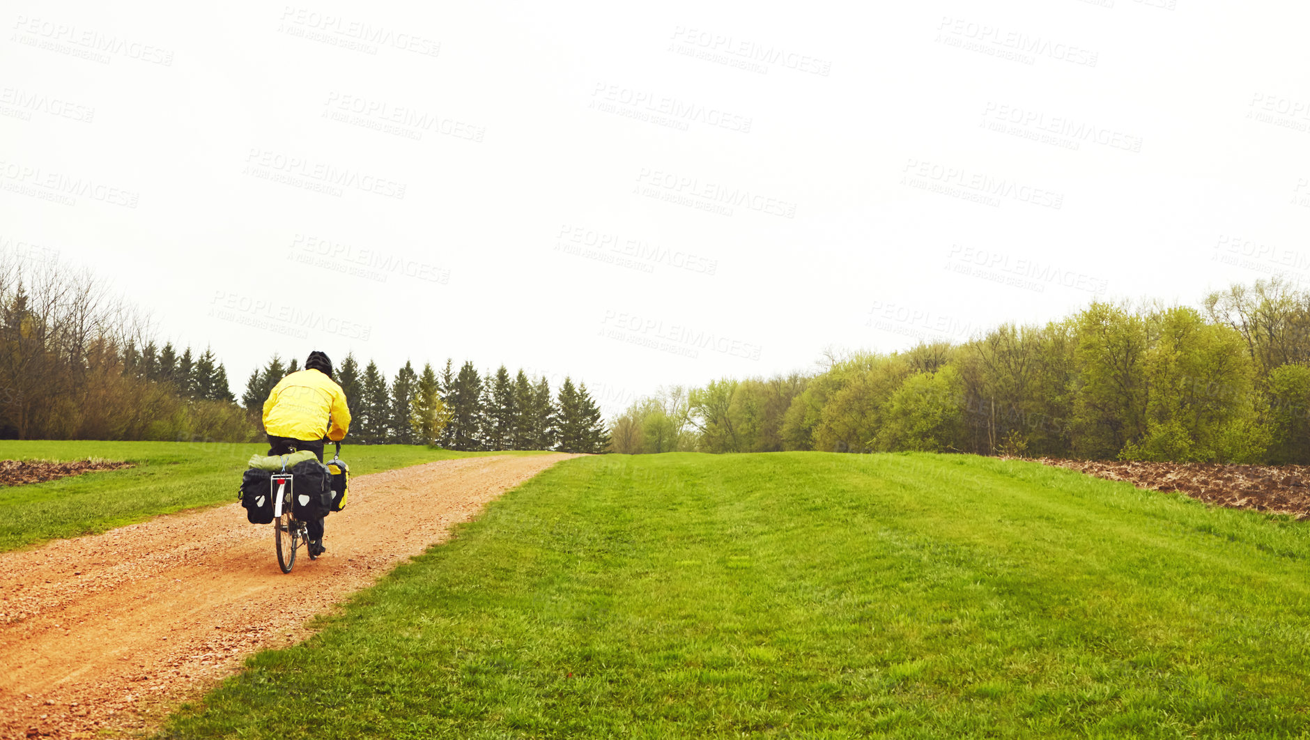 Buy stock photo Countryside, cycling and travel with bicycle, outdoor and journey with raincoat, back and adventure. Winter, cyclist and person with eco friendly transport for trip, holiday and space in nature