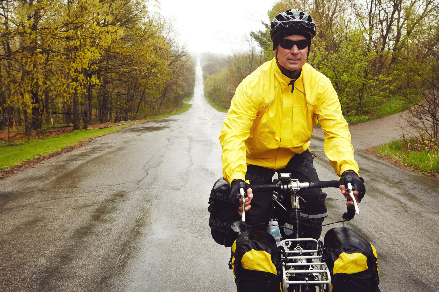 Buy stock photo Cropped shot of a male cyclist enjoying a bike ride on a wet winter's morning