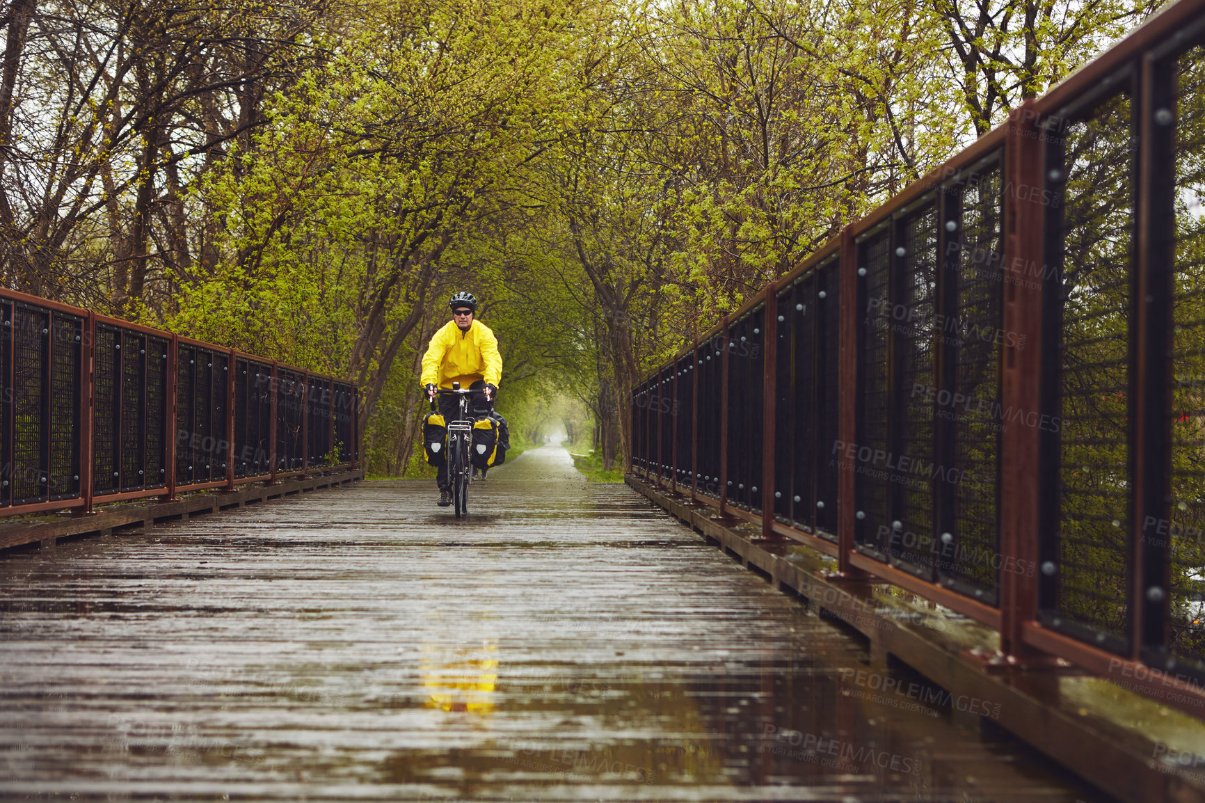 Buy stock photo Full length shot of a male cyclist enjoying a bike ride on a wet winter's morning