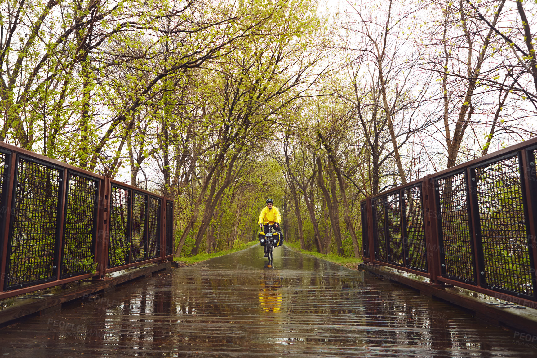 Buy stock photo Full length shot of a male cyclist enjoying a bike ride on a wet winter's morning