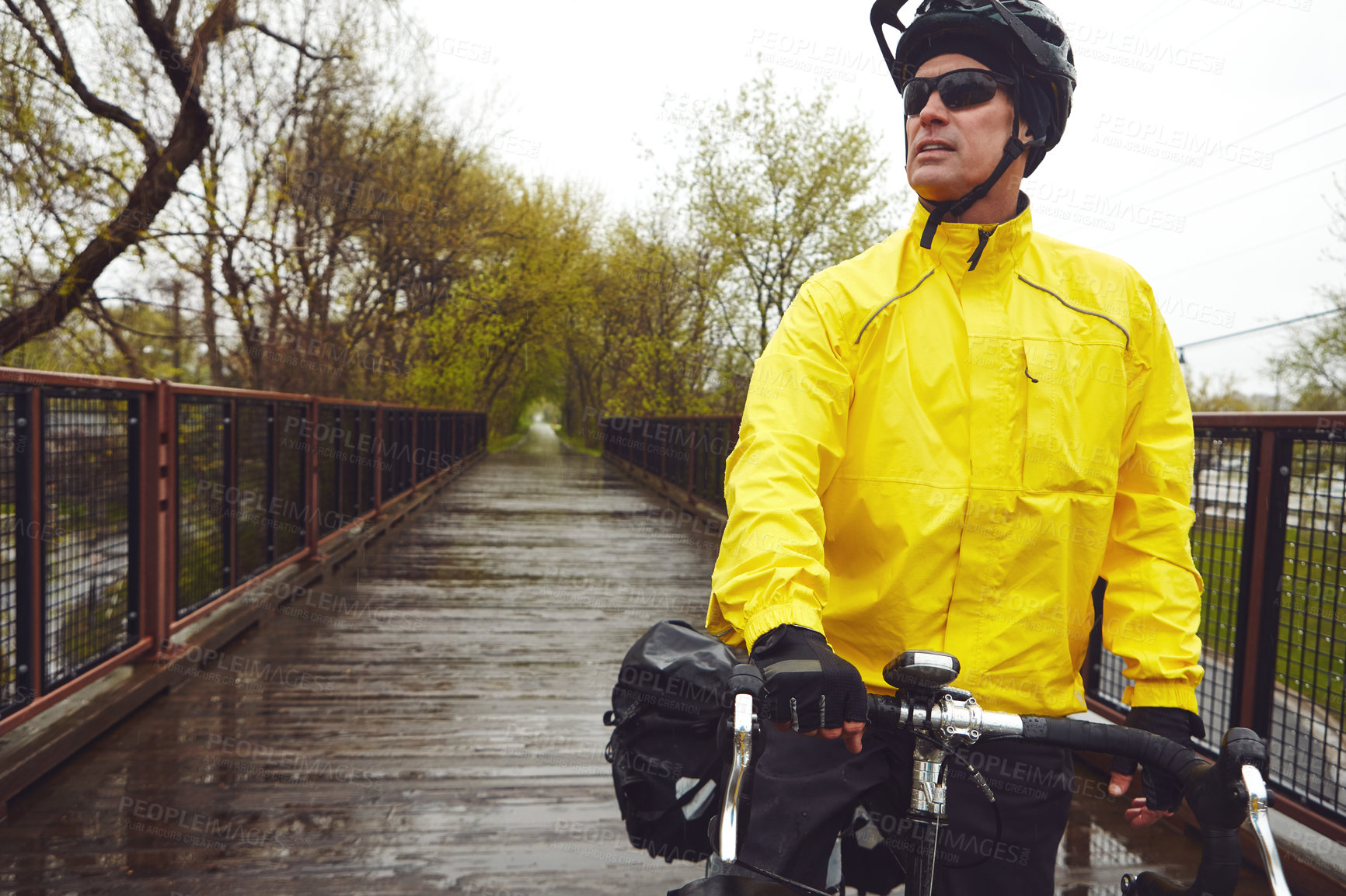 Buy stock photo Cropped shot of a male cyclist enjoying a bike ride on a wet winter's morning