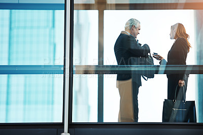 Buy stock photo Shot of a businessman and businesswoman having a discussion in a modern glass office