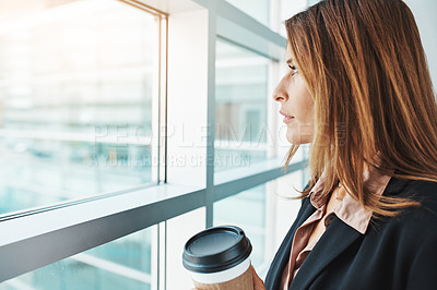 Buy stock photo Shot of a businesswoman looking out of the window in a modern office