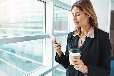 Buy stock photo Shot of a businesswoman using a mobile phone in a modern office