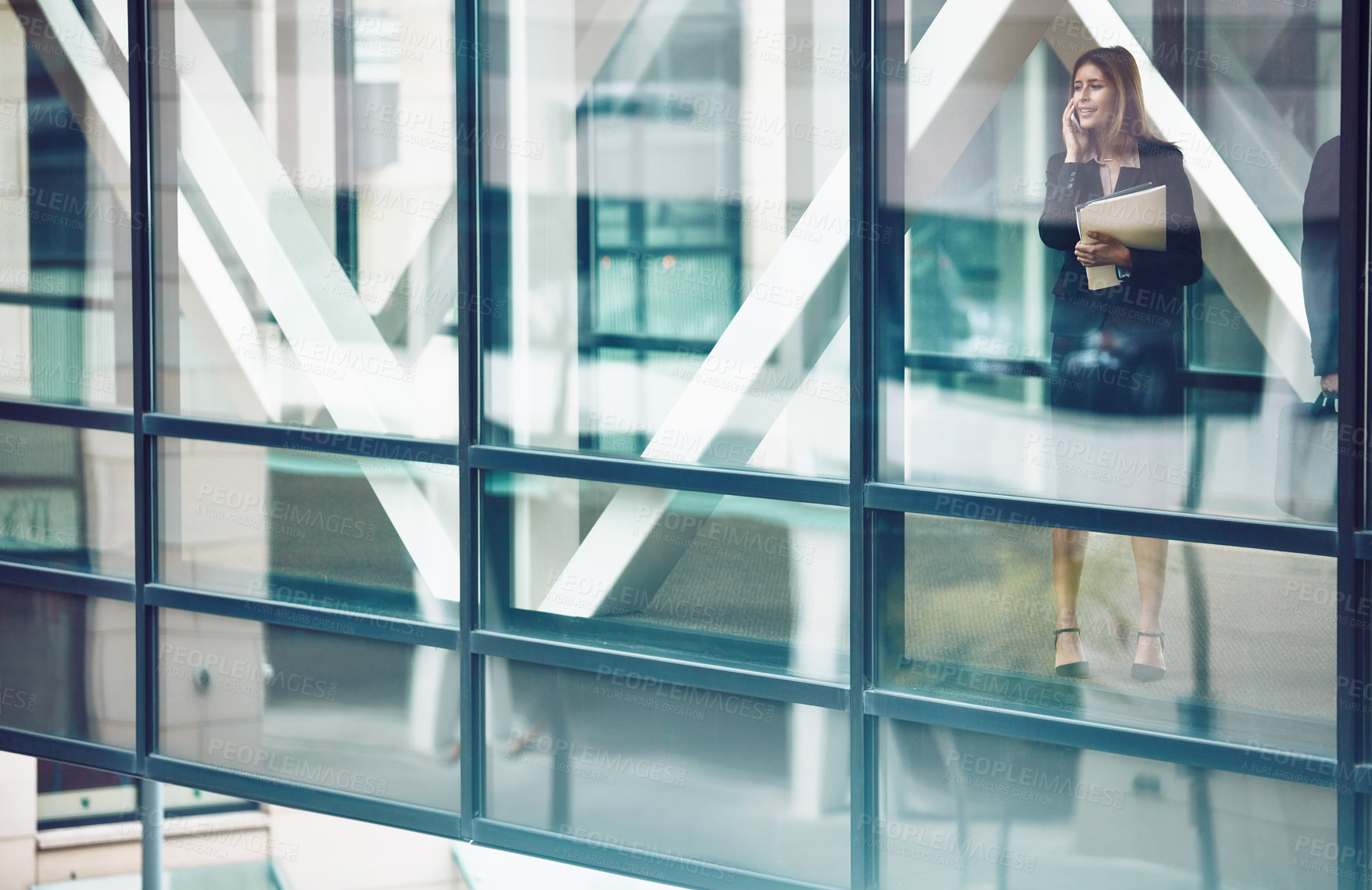 Buy stock photo Shot of a businesswoman using a mobile phone in a modern glass office