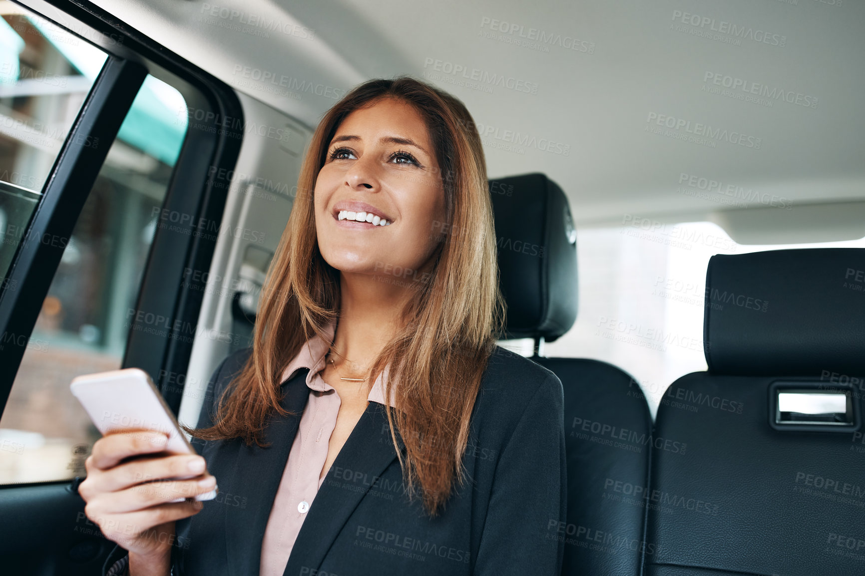 Buy stock photo Shot of a mature businesswoman using a mobile phone in the back seat of a car