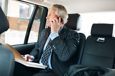 Buy stock photo Shot of a mature businessman using a mobile phone in the back seat of a car