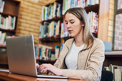 Buy stock photo Cropped shot of a university student doing some research on a laptop