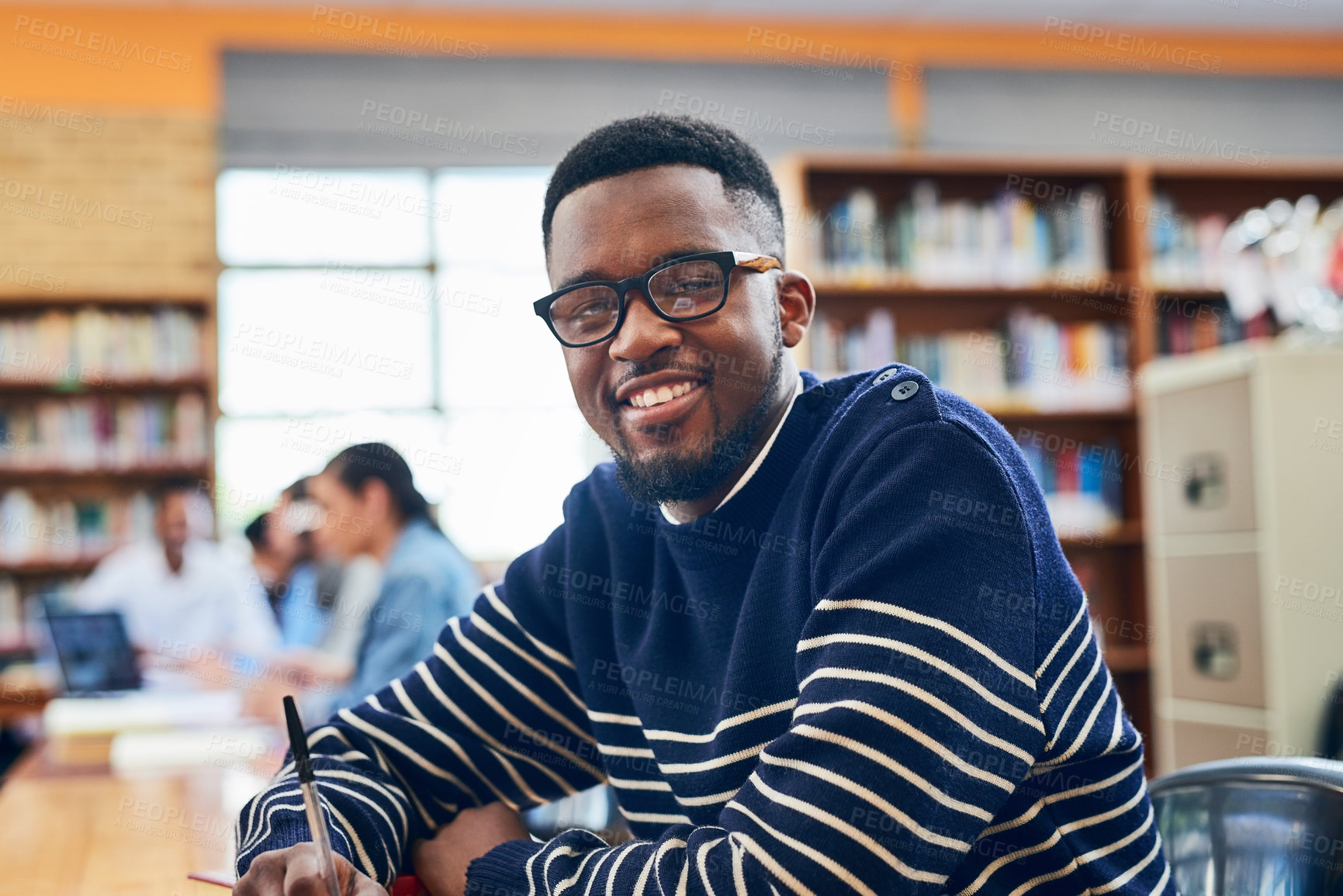 Buy stock photo Black man, student and smile in portrait, library and writing notes for learning, development and research. Person, happy and pride with education, scholarship and studying at university in Nigeria