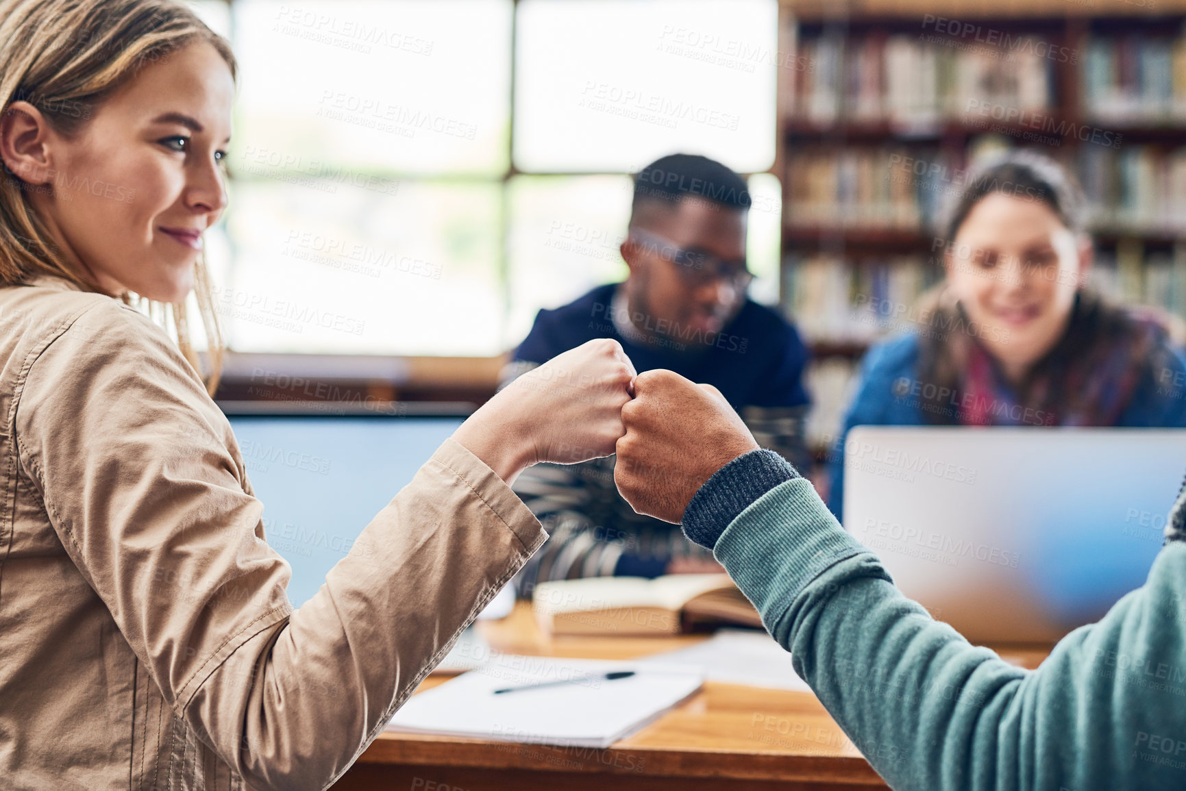 Buy stock photo Woman, students and fist bump in library for education, motivation and celebration with group at campus. People, connection and hands together for solidarity, learning and scholarship at university