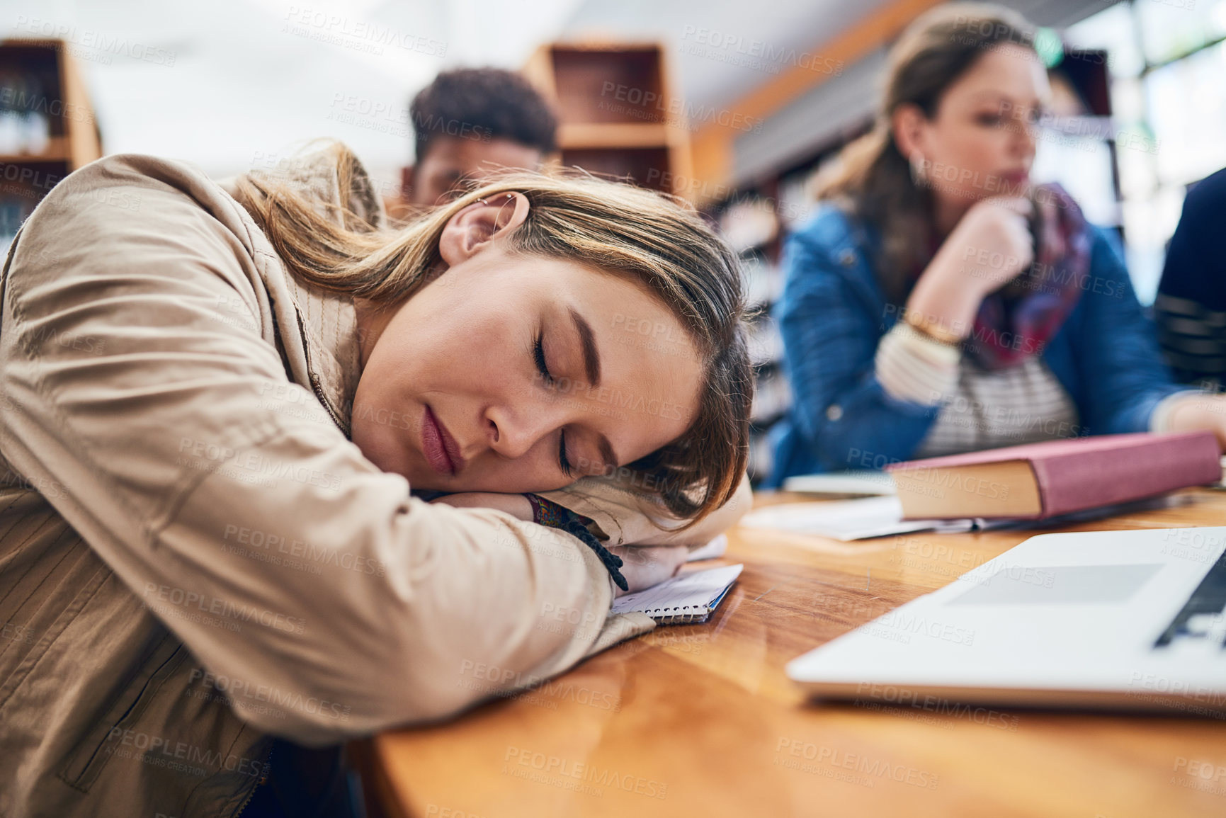 Buy stock photo Woman, student and sleep at college with group, burnout and tired with books, tech and education in library. Person, fatigue and exhausted with studying, learning or development in hall at university