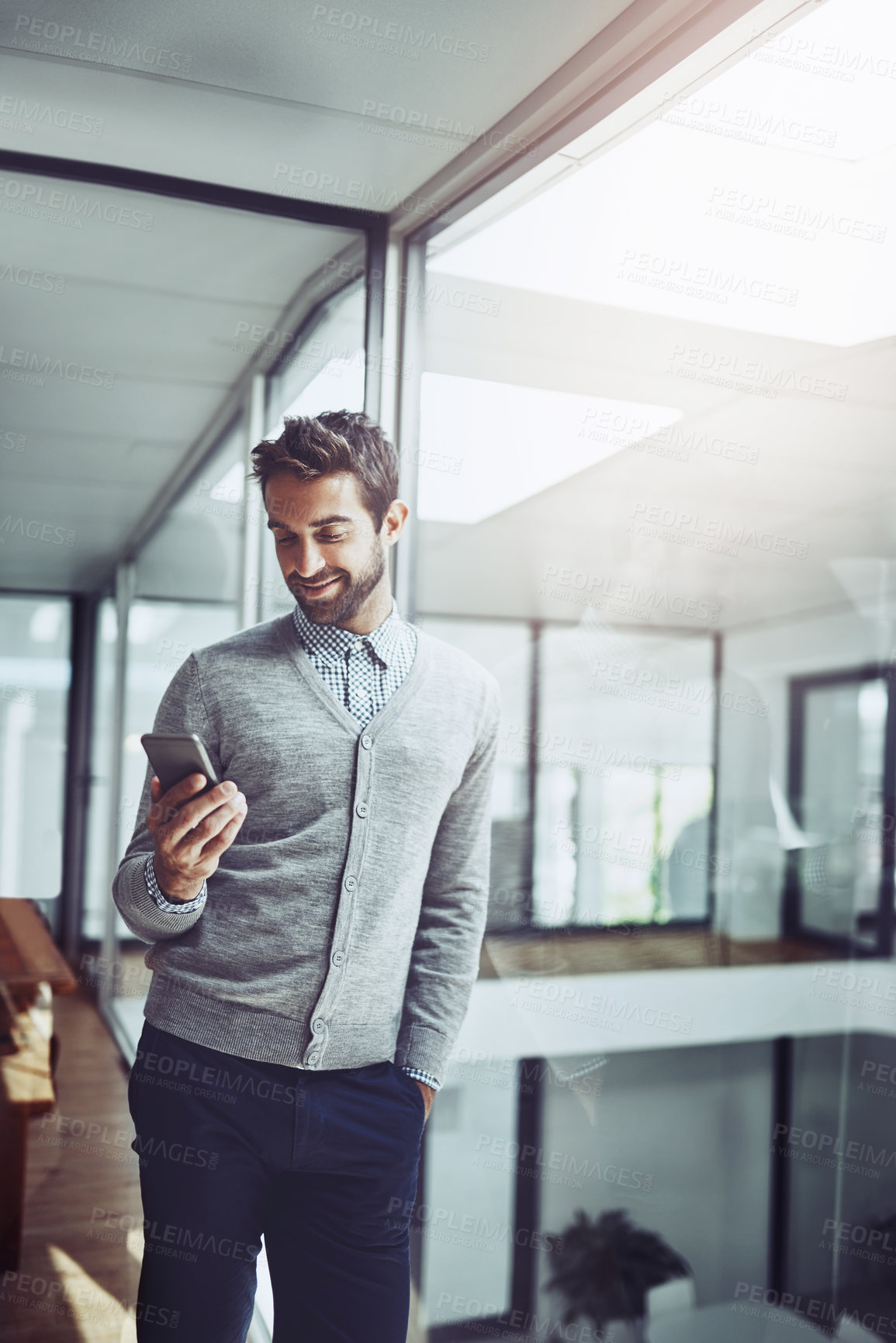 Buy stock photo Businessman, phone and hand in office and standing for email, communication with technology at job. Male person, mobile and holding at workplace with smile for contact, online or connected for career