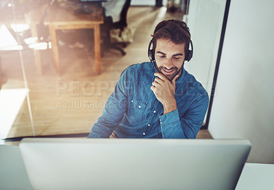 Buy stock photo High angle shot of a handsome young businessman wearing a headset while sitting at his desk