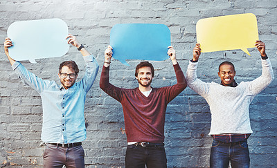 Buy stock photo Portrait of a group of young men holding speech bubbles against a brick wall