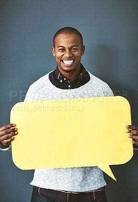 Buy stock photo Studio portrait of a young man holding a speech bubble against a grey background