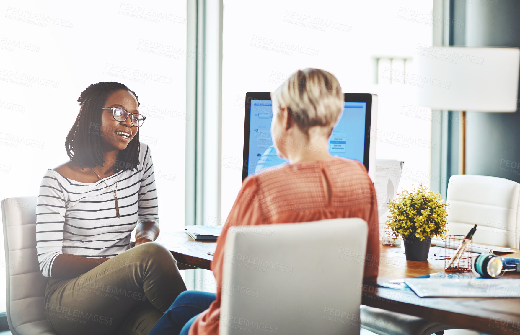 Buy stock photo Shot of two businesswomen having a discussion in an office