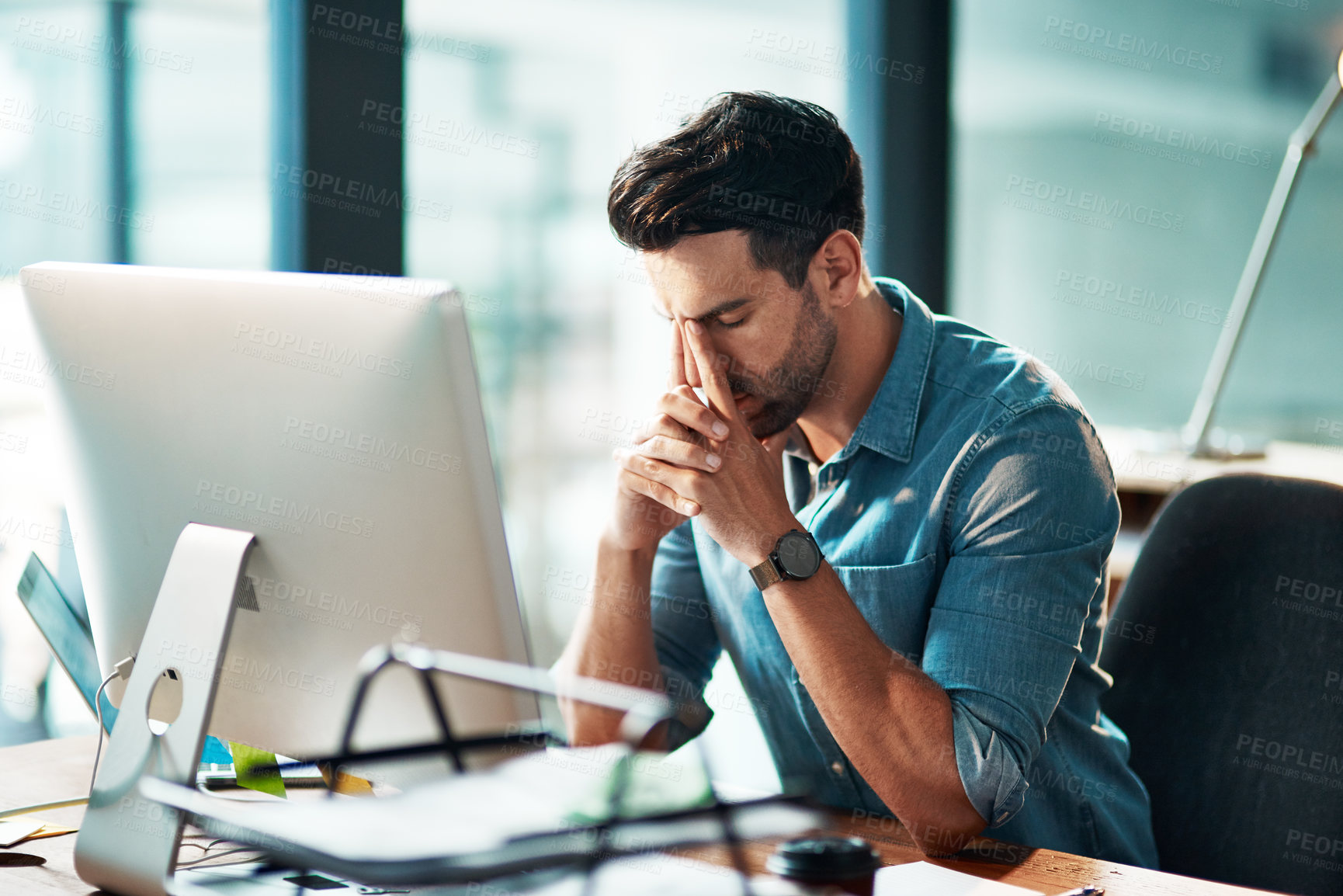 Buy stock photo Businessman suffering from a headache or migraine due to stress caused by deadlines and work pressures. Professional in pain feeling anxious, overwhelmed and stressed while busy on his computer desk