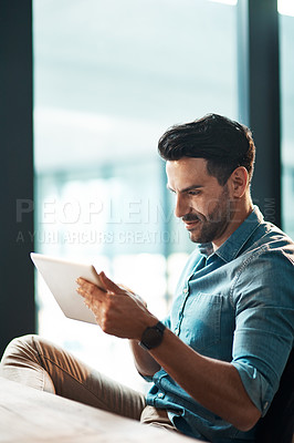 Buy stock photo Serious businessman typing on a digital tablet in his office. Handsome male entrepreneur and executive using modern technology to communicate and network with clients using online app or via email
