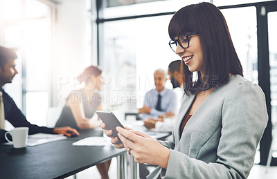 Buy stock photo Cropped shot of an attractive young businesswoman using her tablet during a meeting in the boardroom