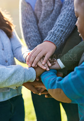 Buy stock photo Shot of a group of unrecognizable elementary school kids joining their hands together in a huddle outside