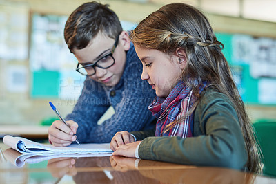 Buy stock photo Shot of two elementary school kids working together in class