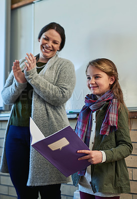Buy stock photo Shot of a teacher applauding an elementary school girl reading in front of the class