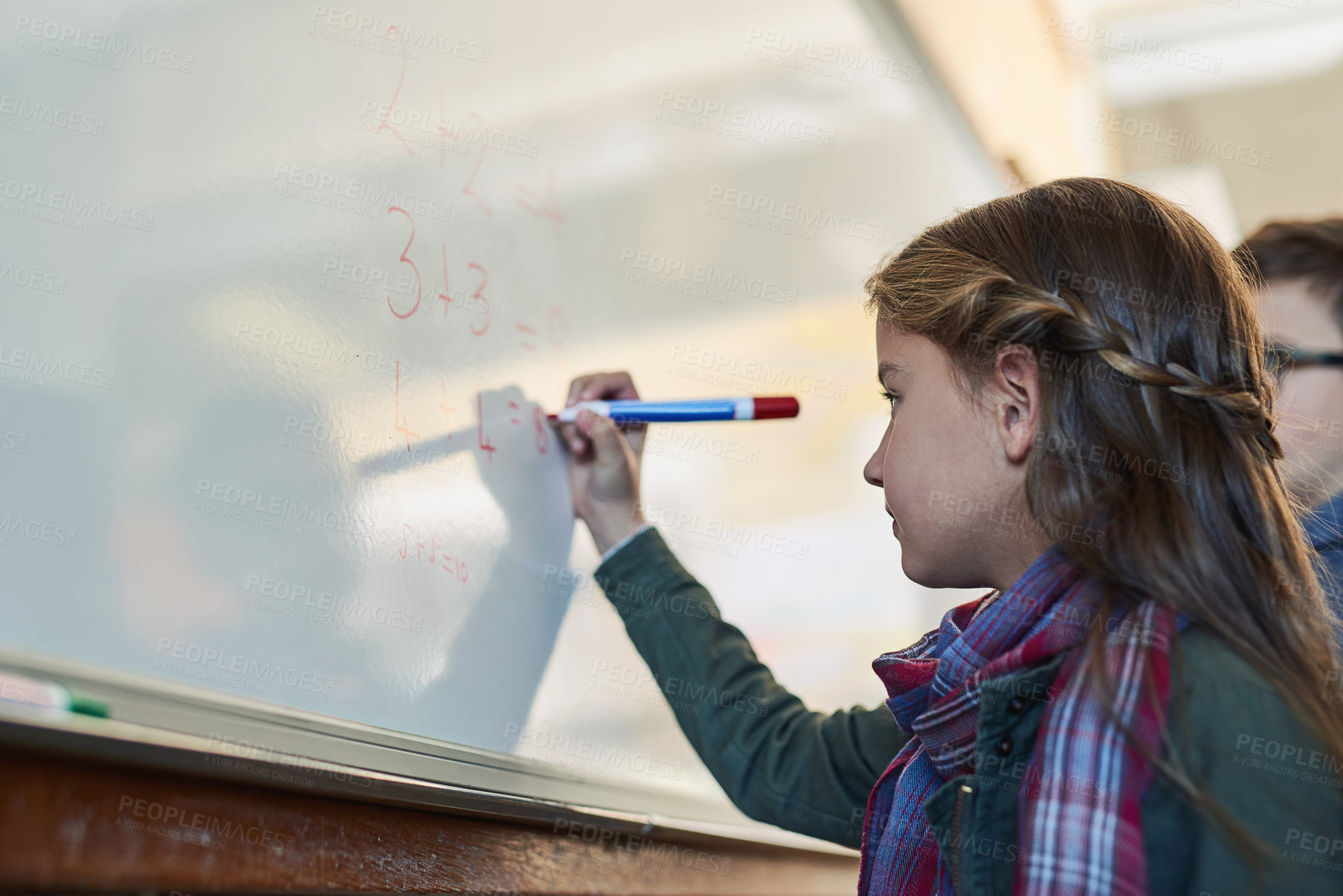 Buy stock photo Shot of an elementary school girl writing on a whiteboard in class