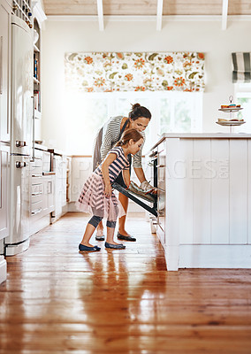 Buy stock photo Food, mother with her child baking and in the kitchen of their home with a lens flare. Happy family or bonding time, bake or cook and woman with girl at the oven prepare a meal for lunch together