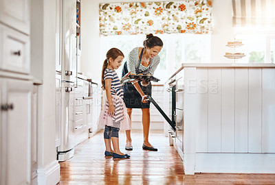 Buy stock photo Food, mother with a girl baking and in the kitchen of their home together with a lens flare. Happy family or bonding time, bake or cook and woman with her daughter prepare meal for lunch at oven