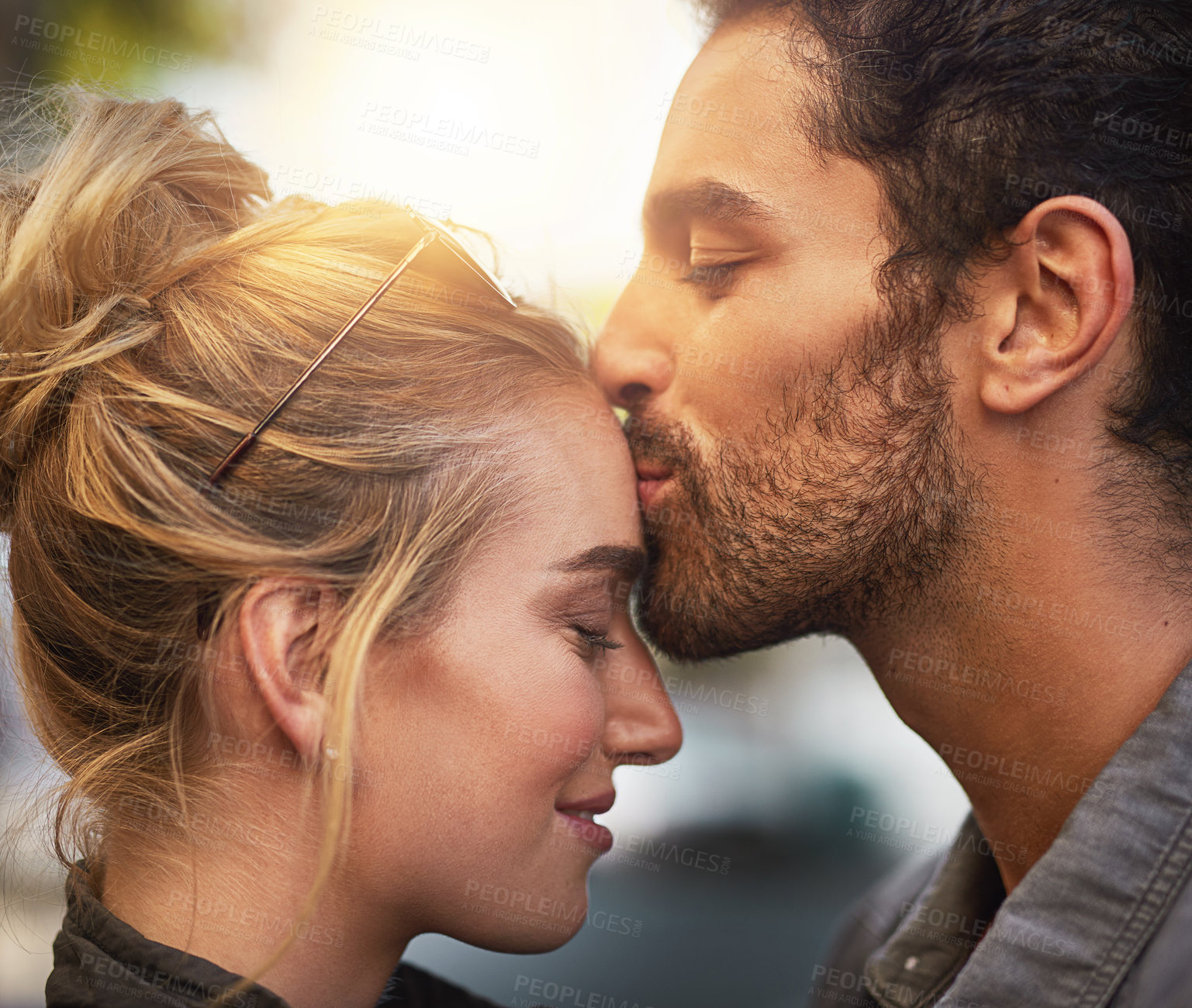 Buy stock photo Cropped shot of a young man kissing his girlfriend's forehead