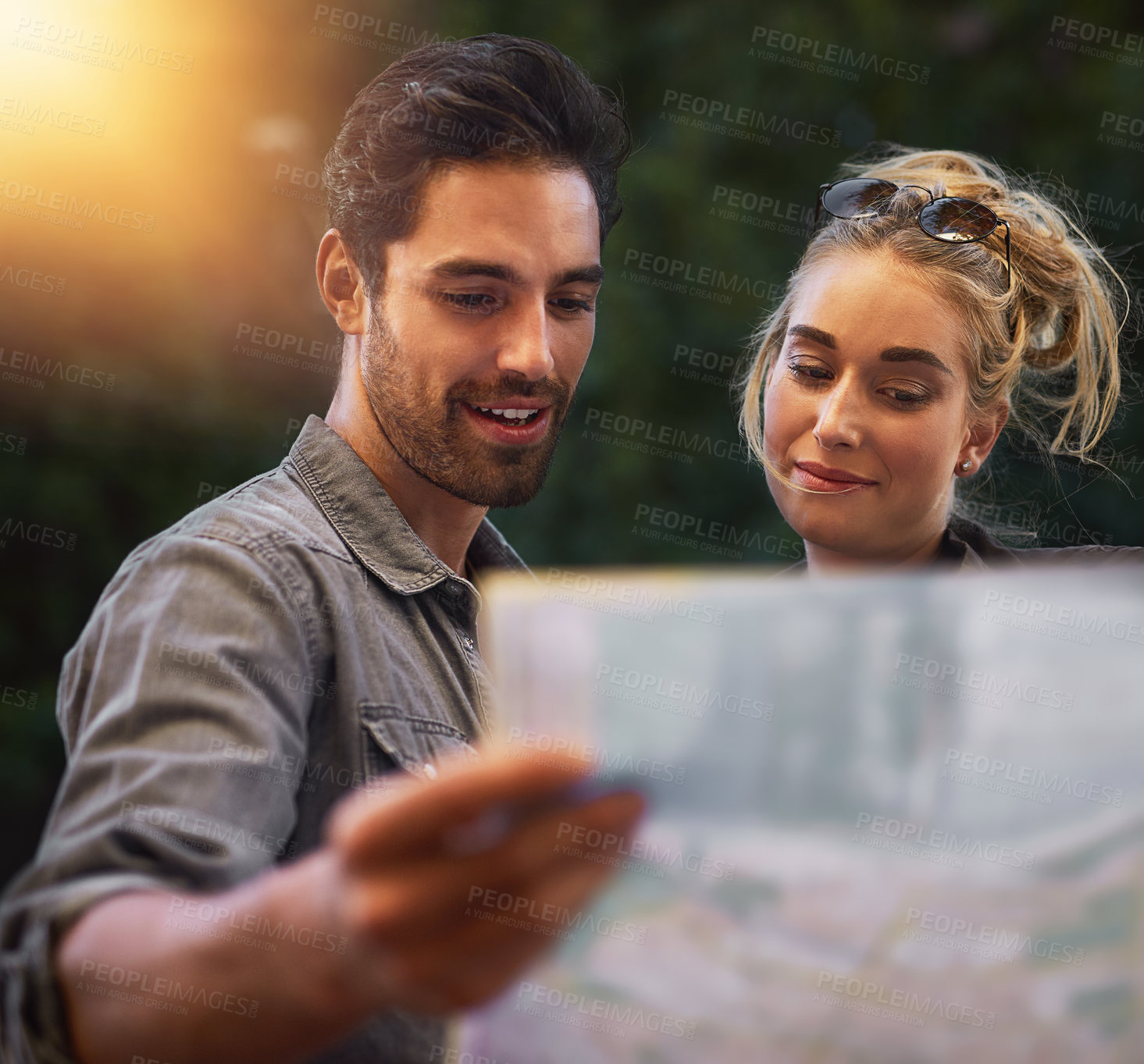 Buy stock photo Shot of a young couple using a map while exploring the city