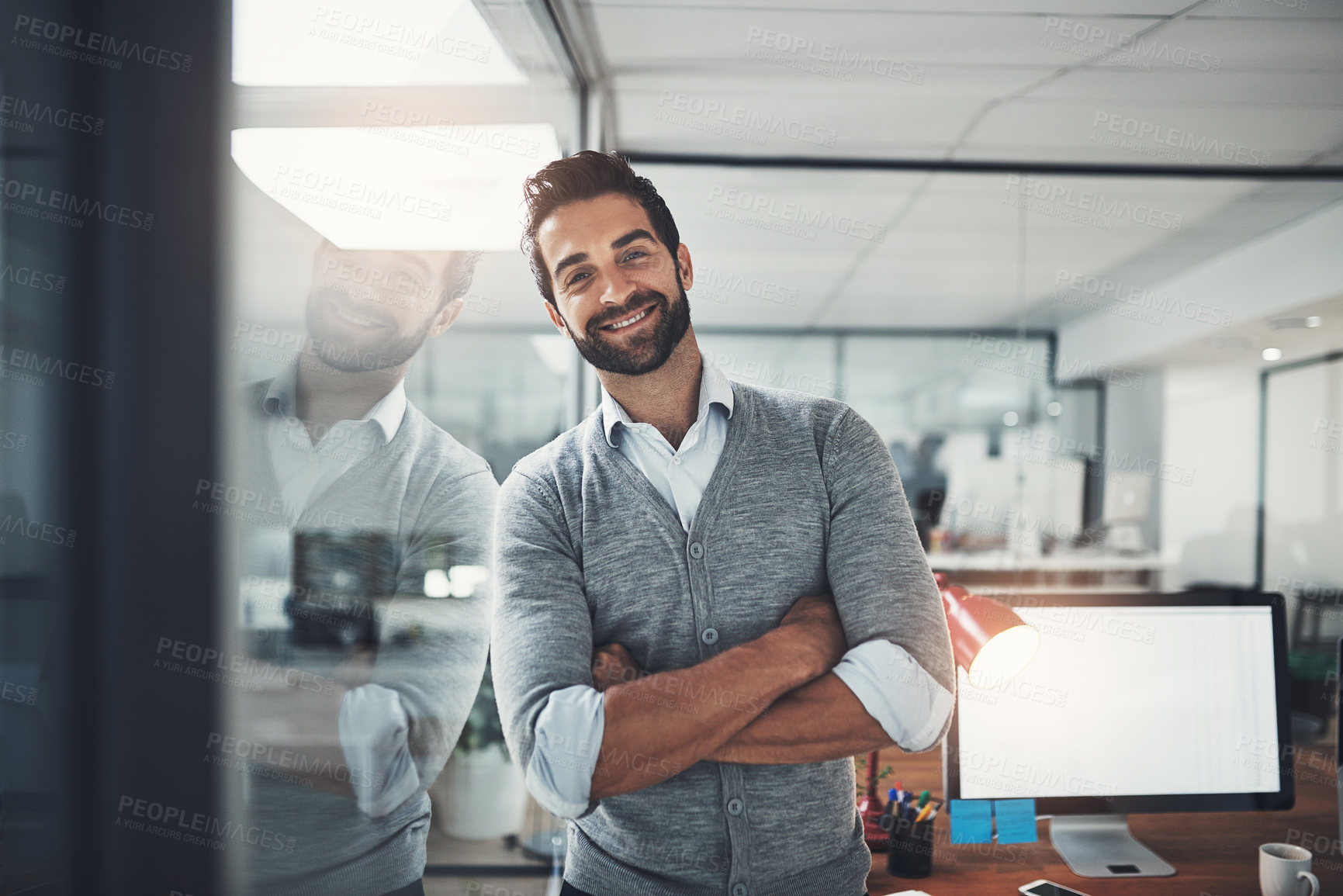 Buy stock photo Portrait, smile and man at window in office with computer screen, pride and project management at startup. About us, professional consultant or businessman with arms crossed, confidence and trust.