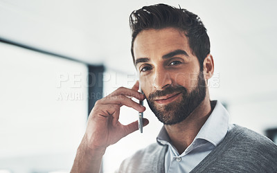 Buy stock photo Portrait of a young businessman talking on his cellphone in an office