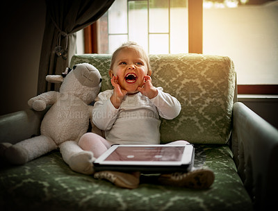 Buy stock photo Shot of an adorable little girl using a digital tablet on the couch at home