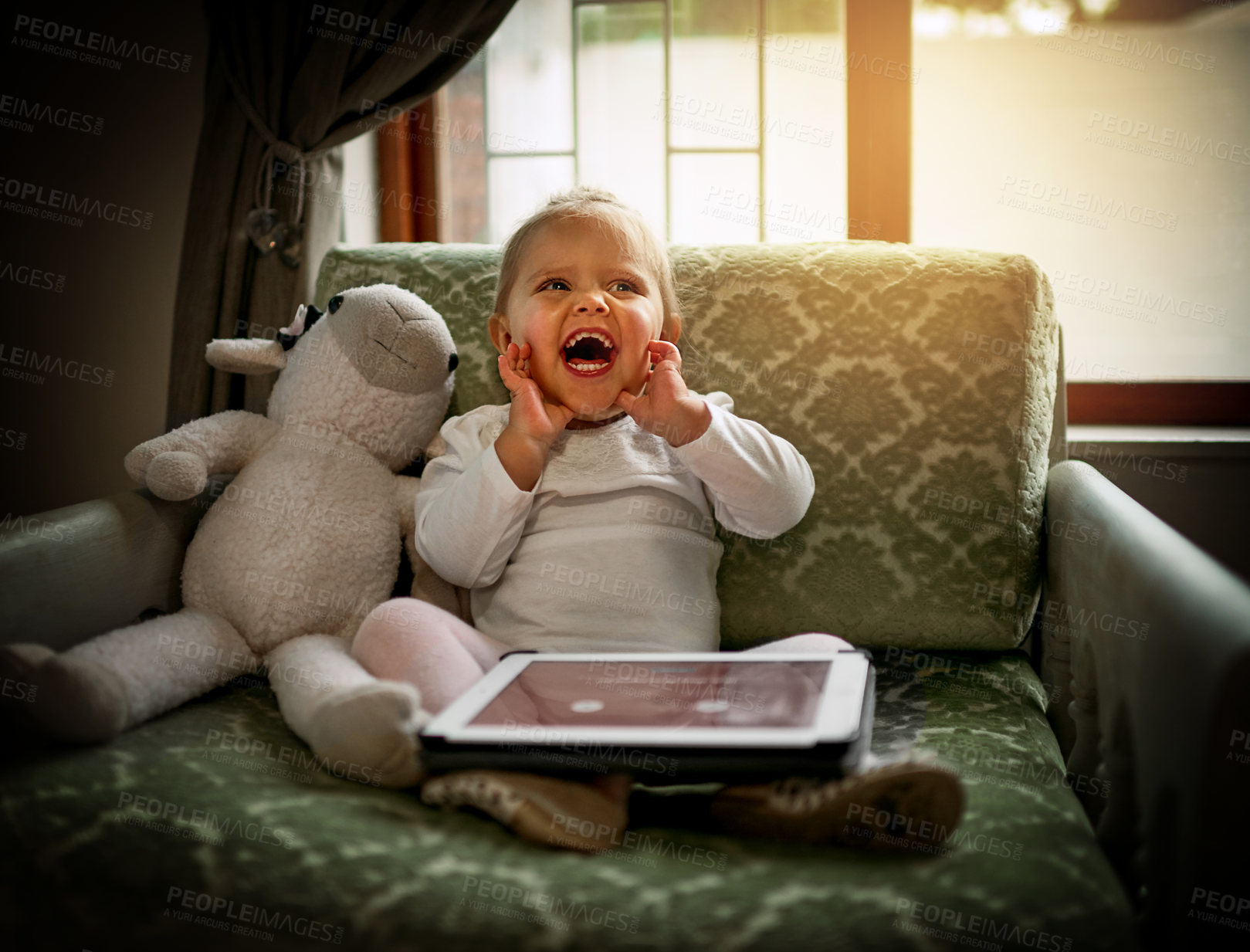 Buy stock photo Shot of an adorable little girl using a digital tablet on the couch at home