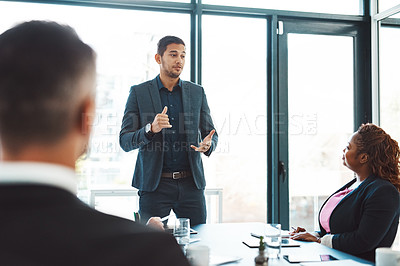 Buy stock photo Cropped shot of a handsome young businessman giving a presentation in the boardroom