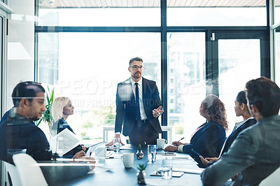 Buy stock photo Cropped shot of a handsome mature businessman giving a presentation in the boardroom