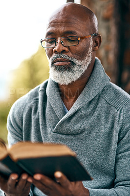 Buy stock photo Cropped shot of a man reading a book outside