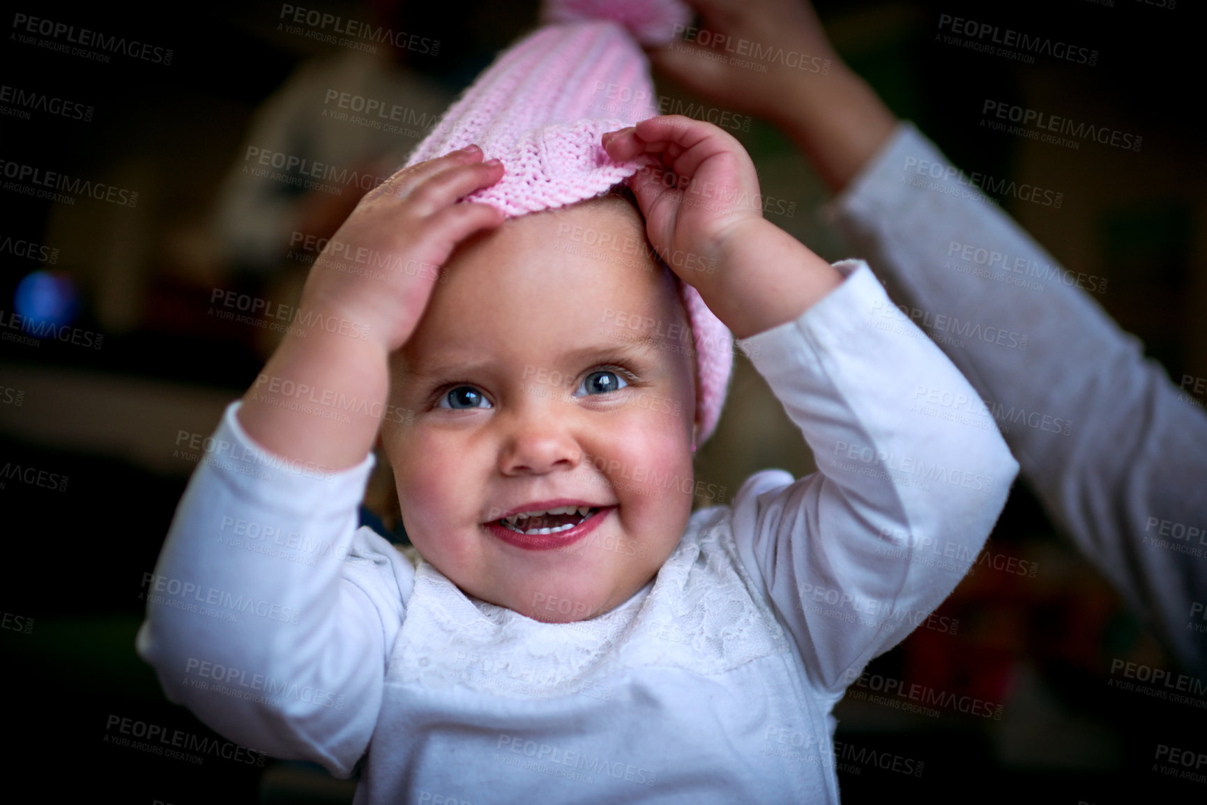 Buy stock photo Cute, smile and hat with baby at home with parent for youth, growth and child development. Happiness, toddler and playful kid with face of young girl at home for childhood, relax and wellness