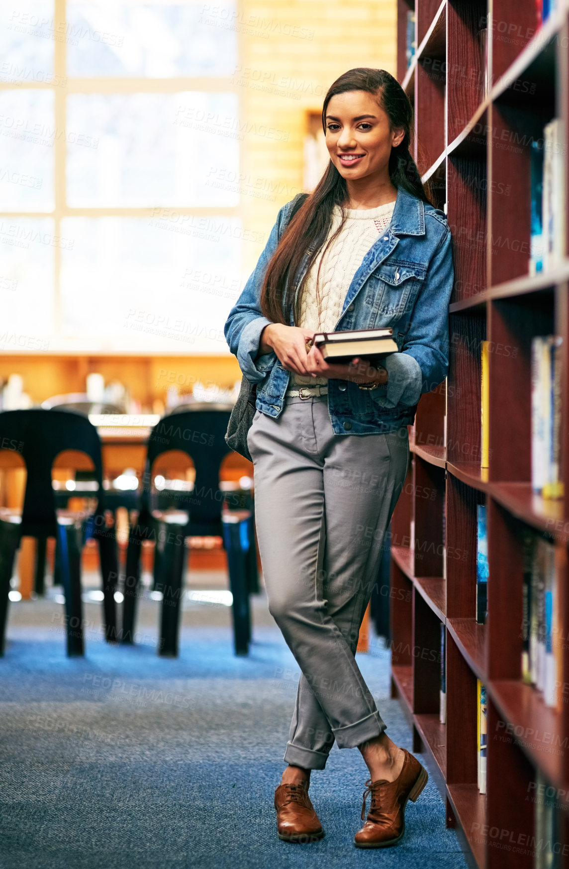 Buy stock photo Portrait of a university student standing in the library at campus