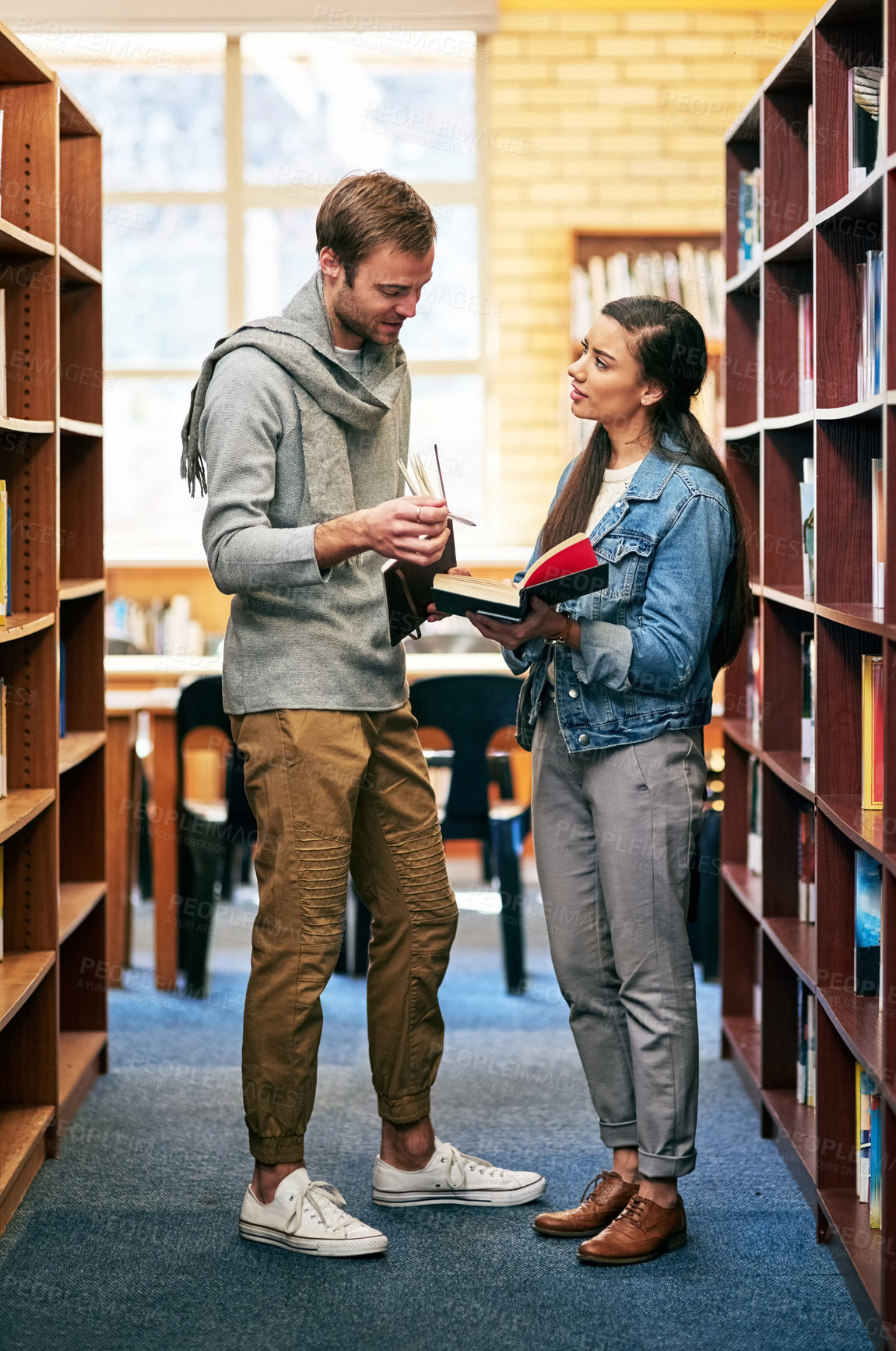 Buy stock photo People, students and library discussion or bookshelf, happy and campus for learning or university education. Conversation, academic scholarship and collaboration, exam preparation and college thesis