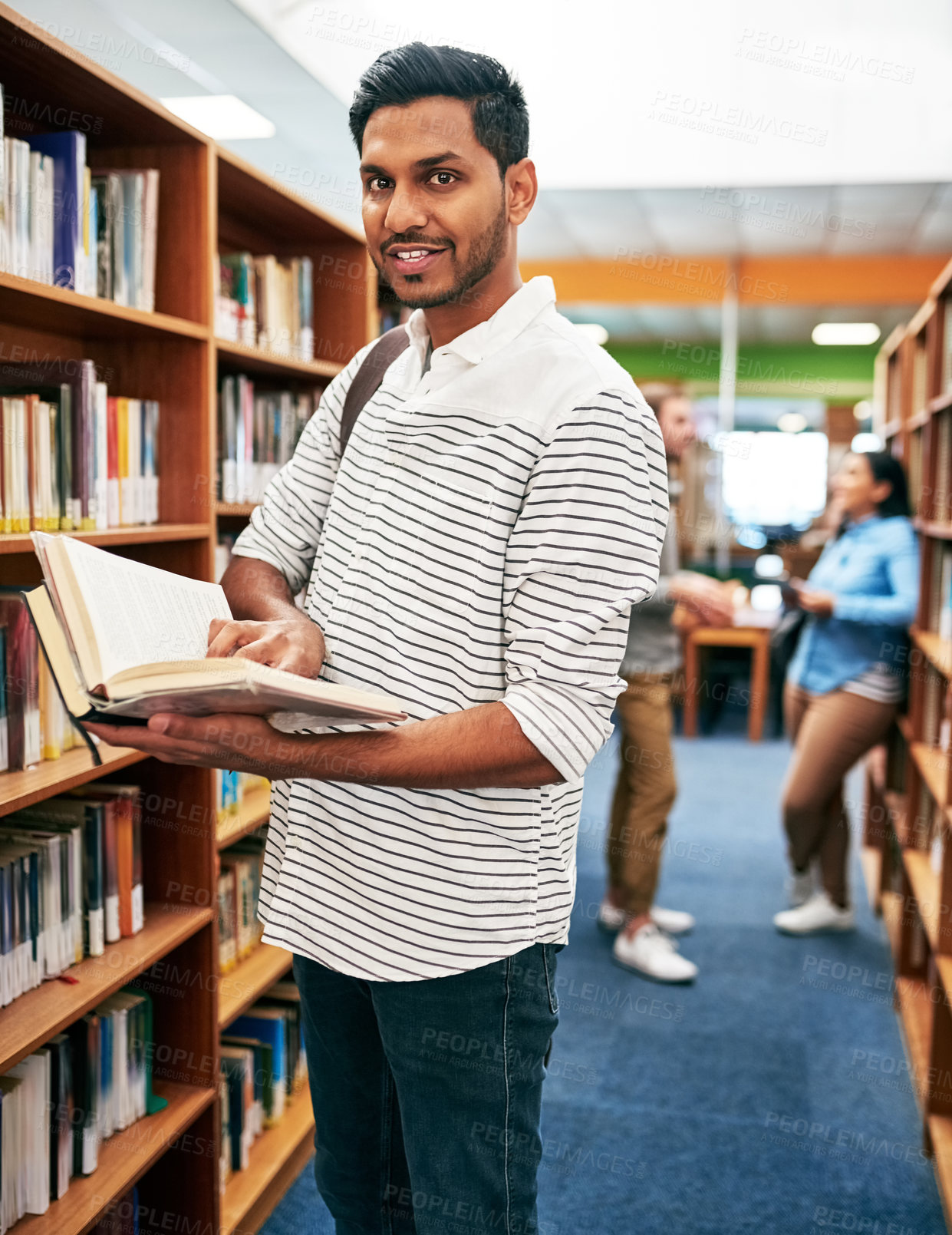 Buy stock photo Portrait, student and Indian man reading book in library for education, learning and study at college. Proud, school and happy male person for research, course knowledge and scholarship at university