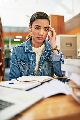 Buy stock photo Portrait of a university student looking stressed out while working in the library at campus