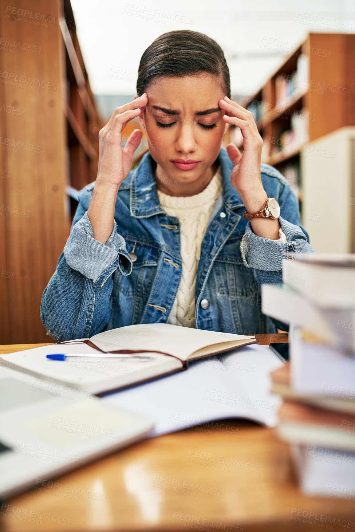 Buy stock photo Woman, student and stress in library with books, education and knowledge study or learning at university with headache. Burnout, anxiety for mental health and frustrated with research assignment 