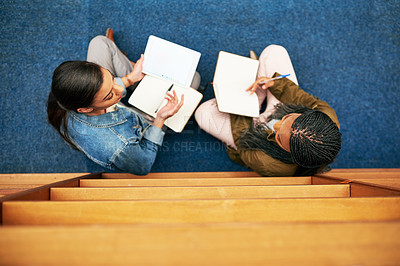 Buy stock photo High angle shot of two university students working together in the library at campus